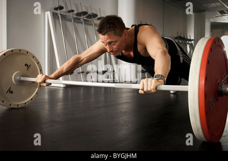 Barbell holding athlète masculin in gym Banque D'Images