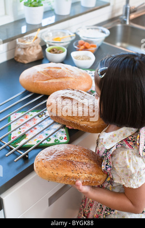 Girl holding fraîchement pain, high angle view Banque D'Images