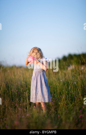 Girl standing on meadow boire de la cuvette Banque D'Images