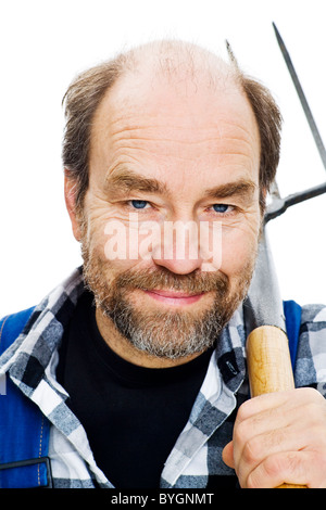 Studio portrait of senior man holding pitchfork Banque D'Images