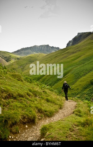 Vue arrière d'une marchette assistée par un poteau de randonnée sur la route d'ascension de Scafell Pike Banque D'Images