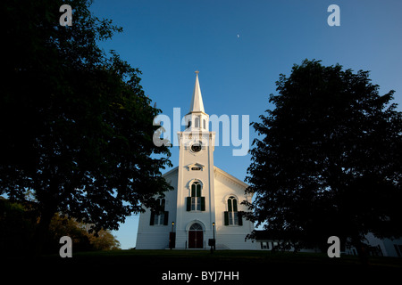 USA, Massachusetts, Yarmouth Port, Setting sun lights white clocher de First Congregational Church sur soirée d'été Banque D'Images