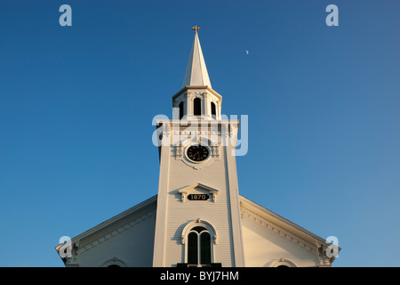 USA, Massachusetts, Yarmouth Port, Setting sun lights white clocher de First Congregational Church sur soirée d'été Banque D'Images