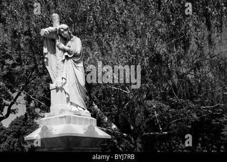 USA, Massachusetts, Lowell, Statue de Christian angel et traverser au sommet tombe, dans le cimetière de matin d'été Banque D'Images