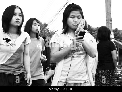 Photographie en noir et blanc de trois jeunes femmes thaïlandaises de marcher le long d'une rue Banque D'Images