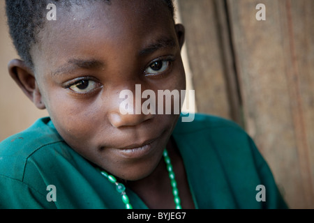 Un jeune enfant est assis à l'extérieur de sa maison dans les régions rurales de Masaka, en Ouganda, en Afrique de l'Est.
