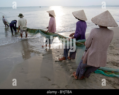 Les FEMMES DU VIETNAM À PARTIR DE LA COOPÉRATIVE DE PÊCHE CASTING NET DANS LA MER PRÈS DE MUI NE Banque D'Images