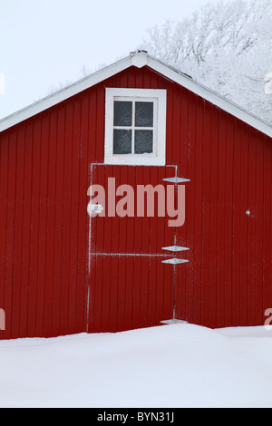 Face de vieille grange rouge avec fenêtre en hiver dans l'Iowa Banque D'Images