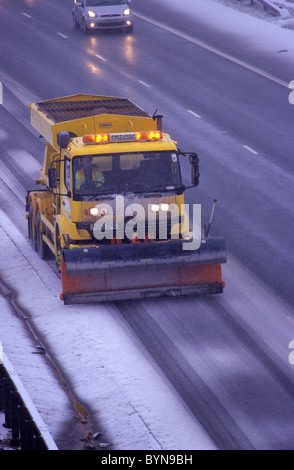 L'épandage de sel sur les saleuses autoroute M1 dans la neige de l'hiver près de Leeds Yorkshire UK Banque D'Images