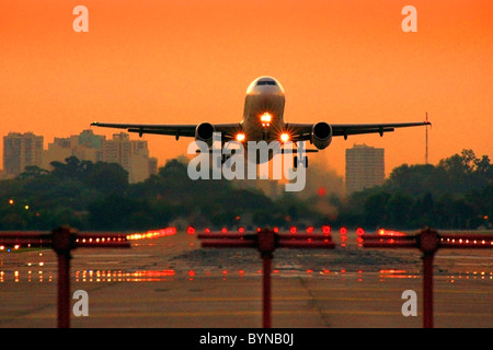 Jet avion de décoller l'aéroport Jorge Newbery, au coucher du soleil. Banque D'Images