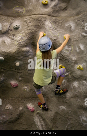 12 ans, fille, sur un mur d'Escalade, Mile End, East London Banque D'Images