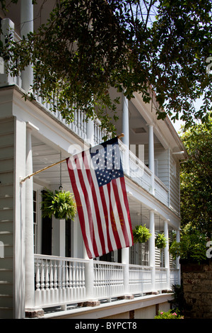 USA, Caroline du Sud, Charleston, drapeau américain vole du portique de l'historique de la maison près de Waterfront Park sur matin d'été Banque D'Images