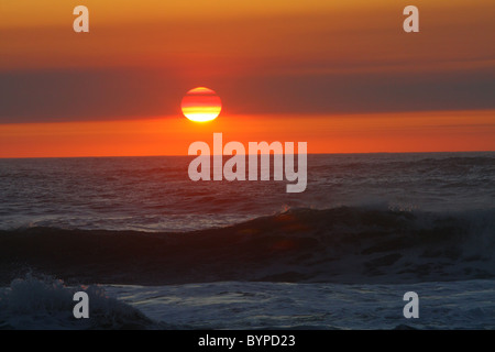 Dark and deep ocean sunset orange avec des vagues agitées et partiellement nuageux ciel. Seal Rock, Oregon, USA, United States. Banque D'Images