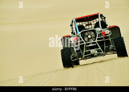 L'arrière de l'ATV buggy des dunes de la conduite sur les dunes de sable jaune dans les régions arides du désert du Namib Swakopmund Namibie Voyage Sport action Transport Banque D'Images