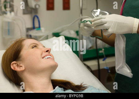 Smiling female patient comme infirmière prépare un masque à oxygène Banque D'Images