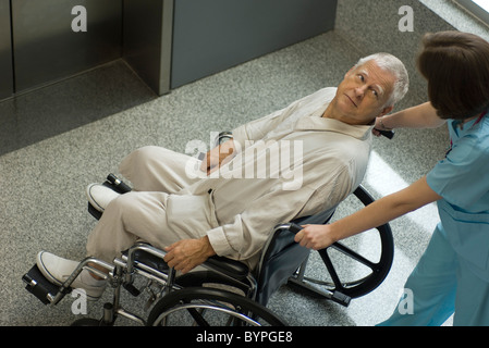 Nurse pushing senior patient in wheelchair Banque D'Images