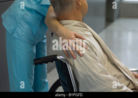 Nurse helping patient in wheelchair, cropped Banque D'Images
