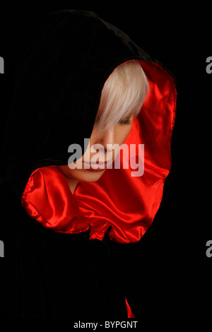 Jeune femme aux cheveux d'argent portant une cape noire bordée de rouge Banque D'Images