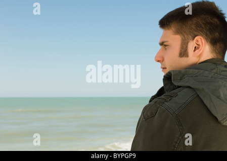 Jeune homme à la plage était à la recherche à afficher Banque D'Images