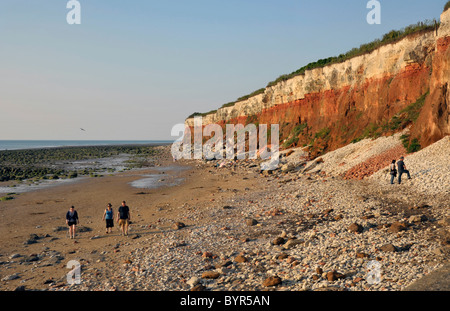 Les marcheurs à côté de rochers, à Hunstanton à Norfolk. Banque D'Images