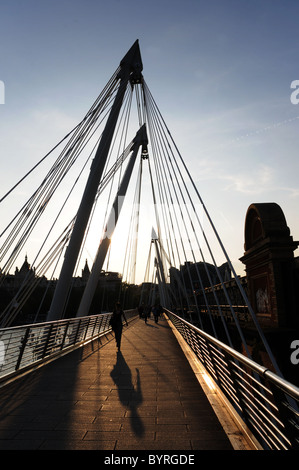 Les gens sur Golden Jubilee Bridge, London au coucher du soleil Banque D'Images