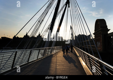 Les gens sur Golden Jubilee Bridge, London au coucher du soleil Banque D'Images