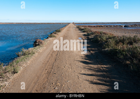 Une piste à travers la zone de production de sel au sud de Gruissan, Languedoc. Banque D'Images