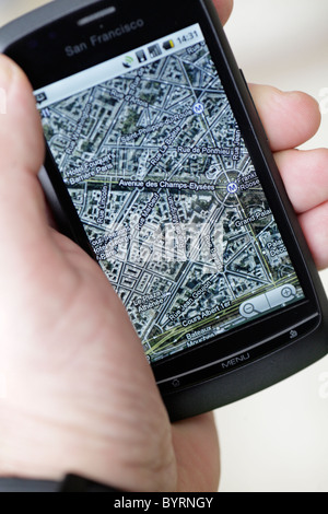 Man looking at google GPS cartes Carte de champs Elysee Paris sur un écran tactile smartphone dans un hotspot wifi libre Banque D'Images
