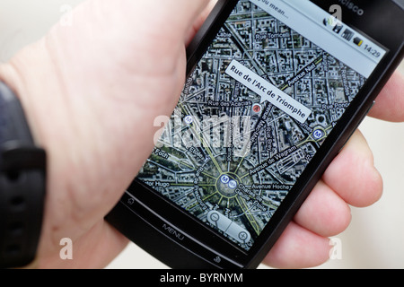 Man looking at google GPS cartes Carte de Paris Arc de Triomphe sur un écran tactile smartphone dans un hotspot wifi libre Banque D'Images
