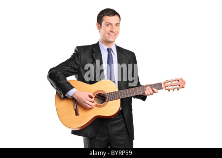 Un jeune homme en costume noir playing acoustic guitar Banque D'Images