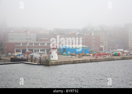 Phare à l'angle de commercial dock en un jour brumeux à port en centre-ville de Saint John, Nouveau-Brunswick, Canada Banque D'Images