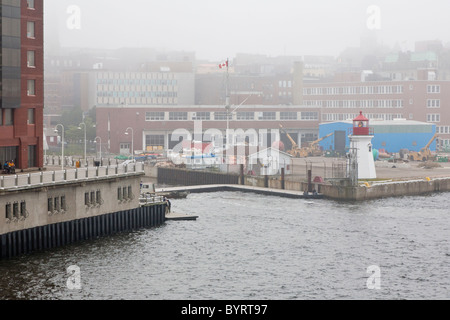 Phare à l'angle de commercial dock en un jour brumeux à port en centre-ville de Saint John, Nouveau-Brunswick, Canada Banque D'Images