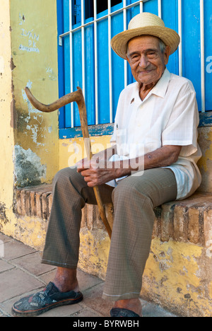 Vieil homme avec un bâton de marche sont assis dans la rue, Trinidad, Sancti Spiritus, Cuba, Caraïbes Banque D'Images