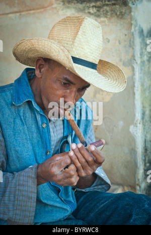 Jeune homme au chapeau de paille allumer un cigare, Trinidad, Sancti Spiritus, Cuba, Caraïbes Banque D'Images