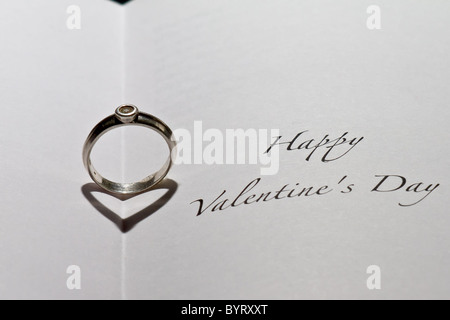 Casting bague cœur ombre dans livre avec la phrase 'Happy Valentine's Day' Banque D'Images