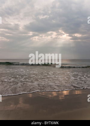 Soleil qui brille à travers les nuages sur un beau matin à la plage Banque D'Images