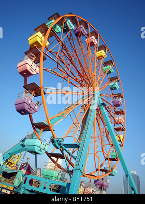 Une grande roue avec des cabines à une foire locale Banque D'Images