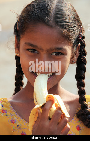 Fille manger une banane de l'Andhra Pradesh en Inde du Sud Banque D'Images