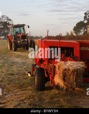 Le tracteur et l'écope dans un coucher de soleil lumière d'automne Banque D'Images