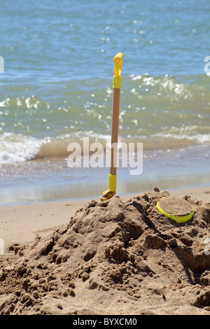 Pelle dans un tas de sable sur la plage près de l'océan Banque D'Images