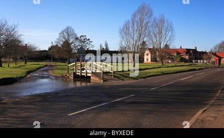 Une Ford et la rivière brûler l'exécution par la route principale traversant Sud Creake, Norfolk, Angleterre, Royaume-Uni, en début de matinée. Banque D'Images