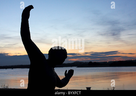 C'était ce grand ! De quelle taille ? Close up of statue avec bras tendus avec le coucher du soleil de la baie de Poole, trous à l'arrière-plan Banque D'Images