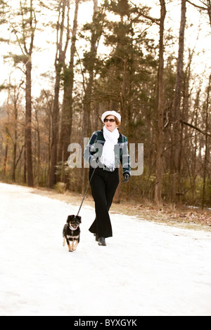 Femme promener son chien dans la neige Banque D'Images