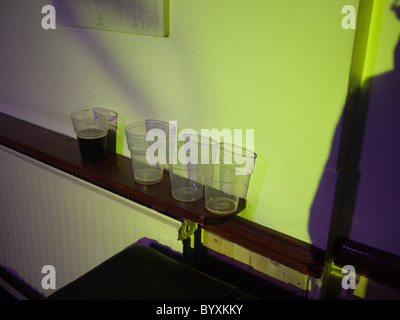 Vide et à moitié vide des verres à bière dans un pub de Londres Banque D'Images