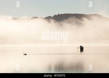 Les pêcheurs de char sur le lac Windermere sur un hivers brumeux matin, Lake District, UK. Banque D'Images