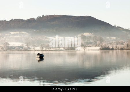 Les pêcheurs de char sur le lac Windermere sur un hivers brumeux matin, Lake District, UK. Banque D'Images