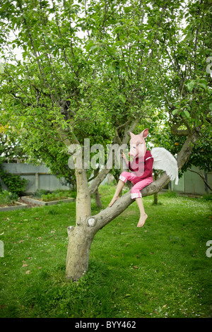 Les cochons peuvent voler. Fille de masque de cochon avec des ailes. Banque D'Images