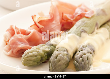 Asperges au jambon en gros plan sur une plaque blanche Banque D'Images