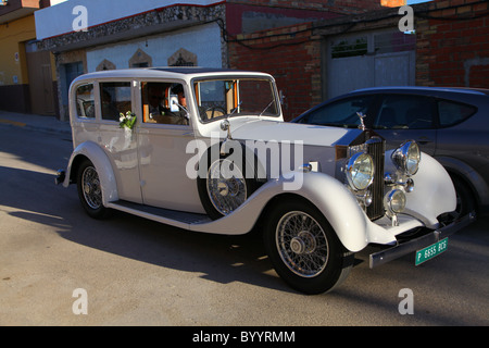 Cortège de mariage espagnol Bride and Groom de partir pour lune de miel à vintage Rolls Royce Banque D'Images