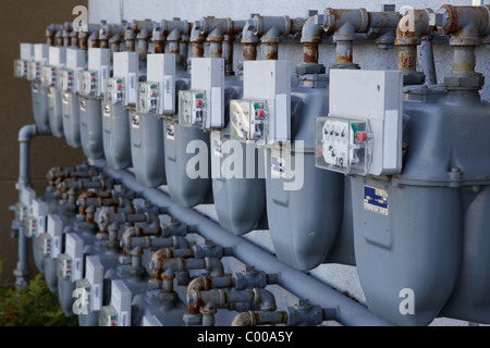 Deux rangées de compteurs de gaz gris à un complexe d'appartements Banque D'Images